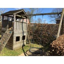 Speelhuis met glijbaan, klimwand en mand(nest)schommel.