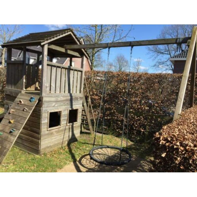 Speelhuis met glijbaan, klimwand en mand(nest)schommel.