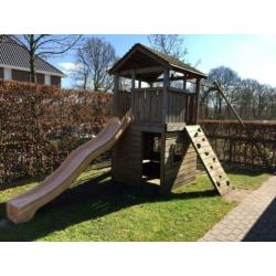 Speelhuis met glijbaan, klimwand en mand(nest)schommel.