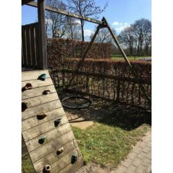 Speelhuis met glijbaan, klimwand en mand(nest)schommel.