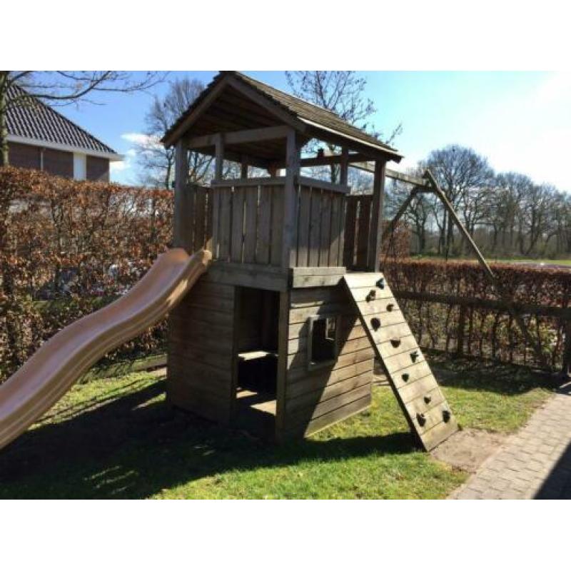 Speelhuis met glijbaan, klimwand en mand(nest)schommel.
