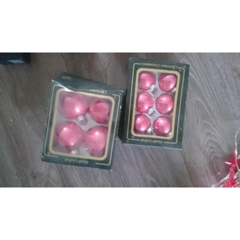 Zilver en roze kerstballen, piek, slingers, lampjes en meer.