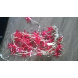 Zilver en roze kerstballen, piek, slingers, lampjes en meer.